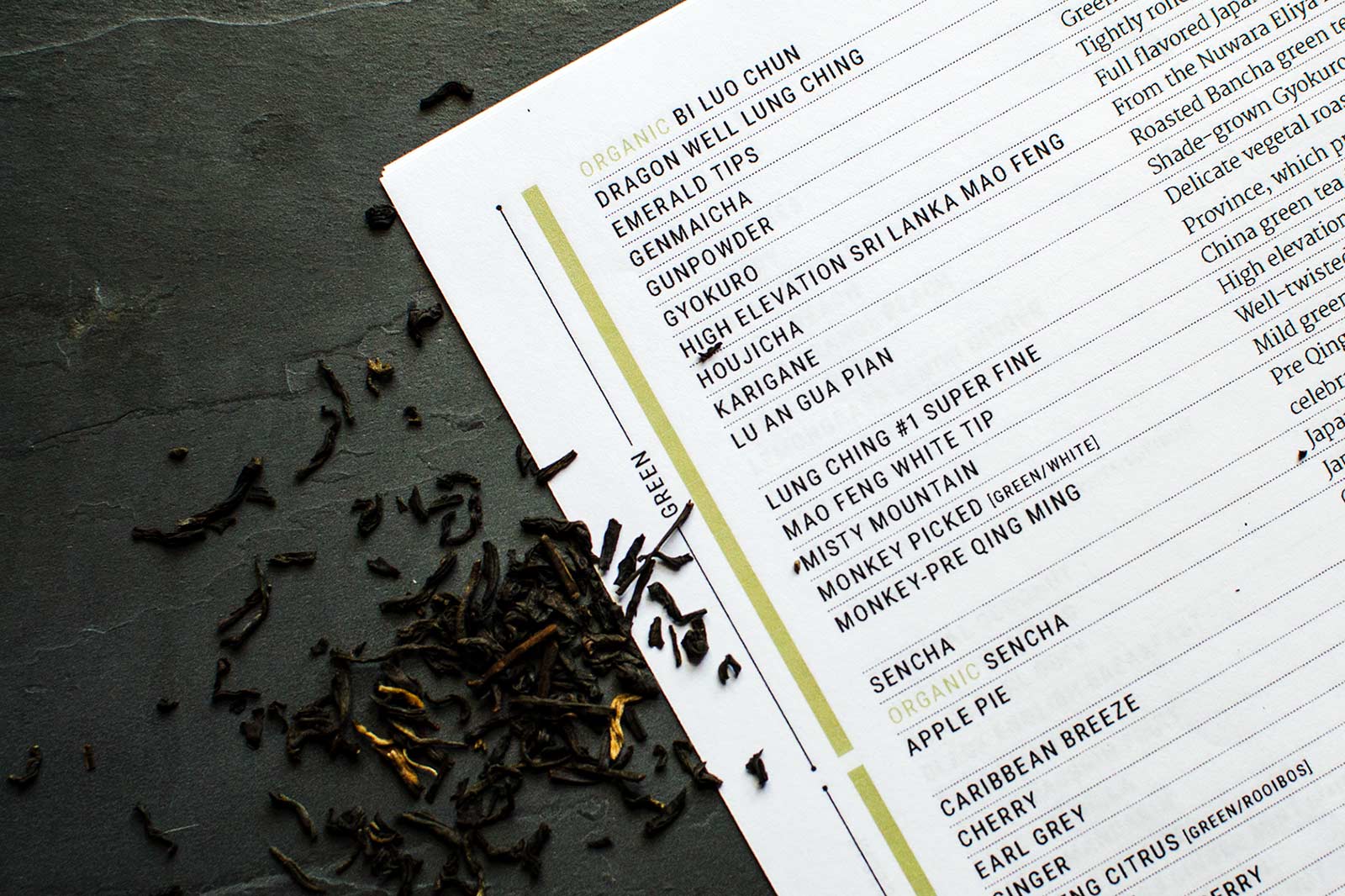 Loose leaf tea is scattered next to ZenTea's tea menu